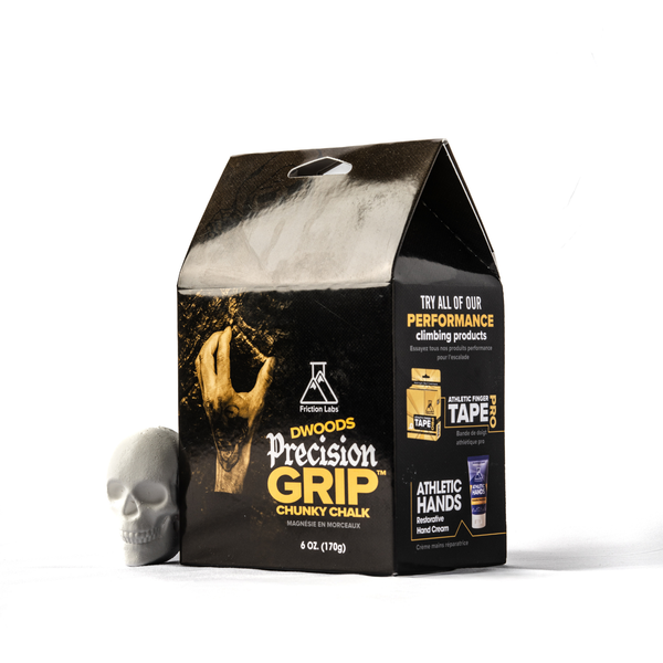 A black and gold bag of Dwoods Precision Grip Chunky Chalk climbing chalk, shown next to a small gray skull on a white background.