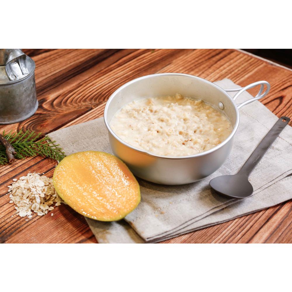 Expedition Foods Hot Cereal with Mango shown in bowl, with spoon and fresh ingredients alongside