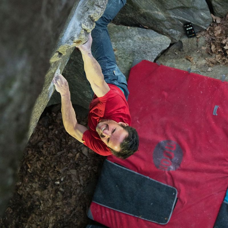 Moon Warrior crash pad in red being used for bouldering