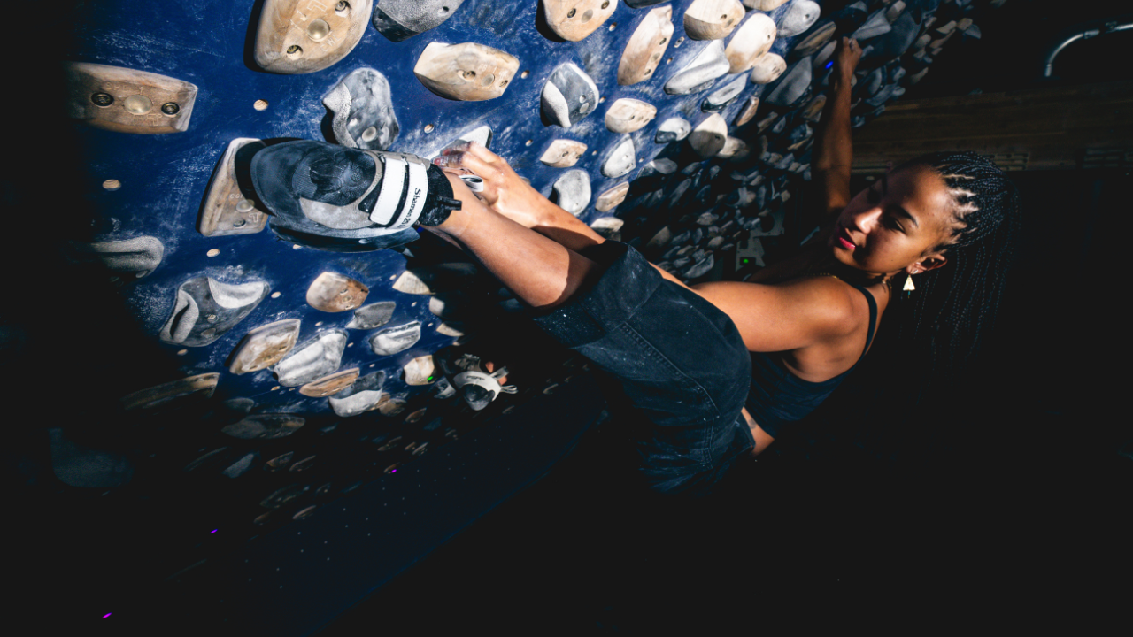 Climbing Shoe Sizing Guide - image of a girls climbing on an indoor training wall.