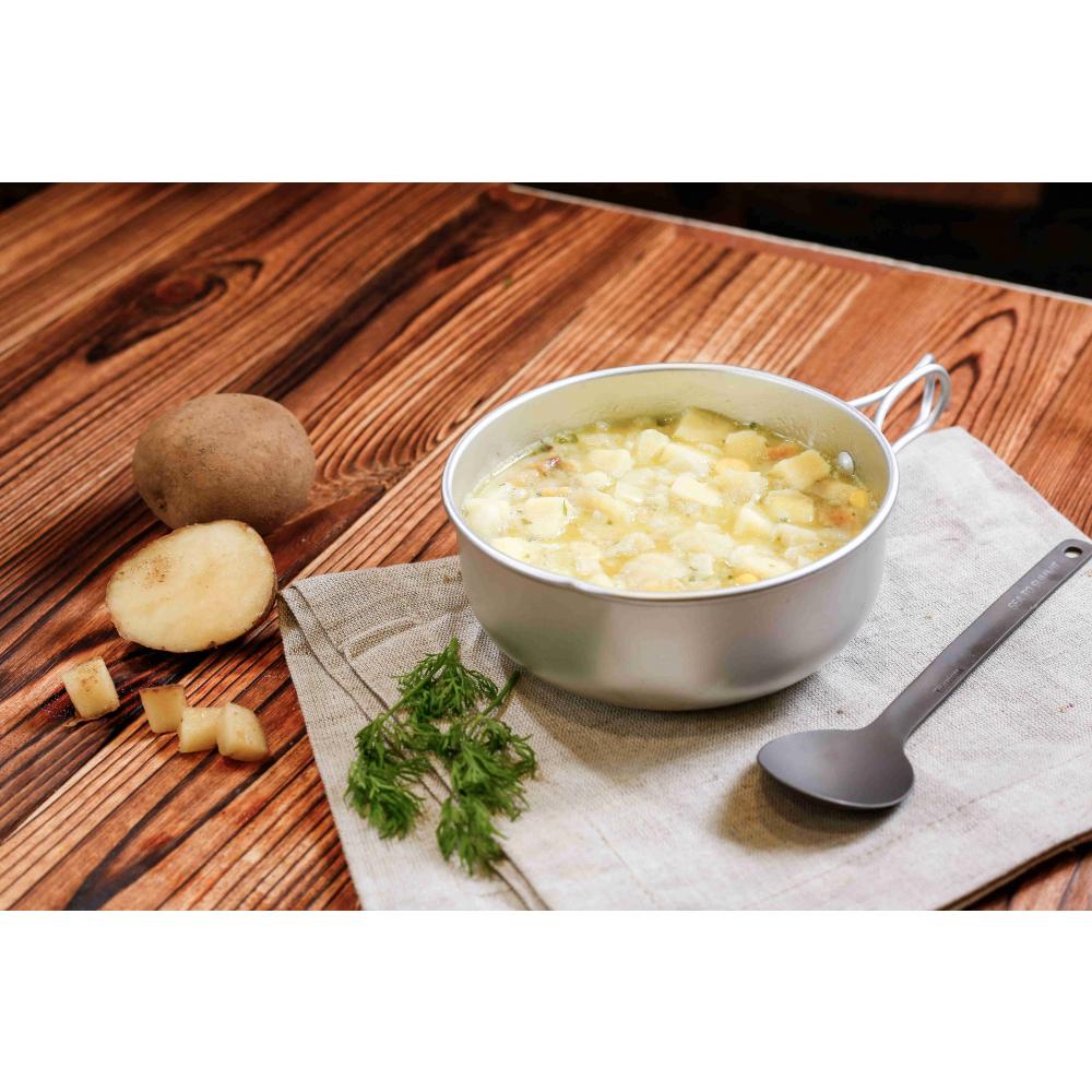 Expedition Foods Fish & Potato with Parsley Sauce in a bowl, shown with spoon and fresh ingredients