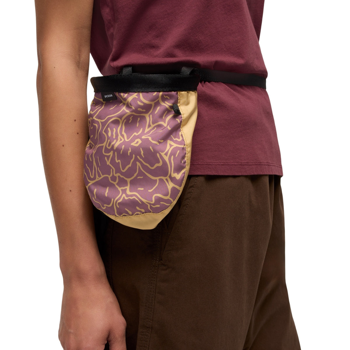 Person wearing a purple and yellow patterned waist bag on a plain background