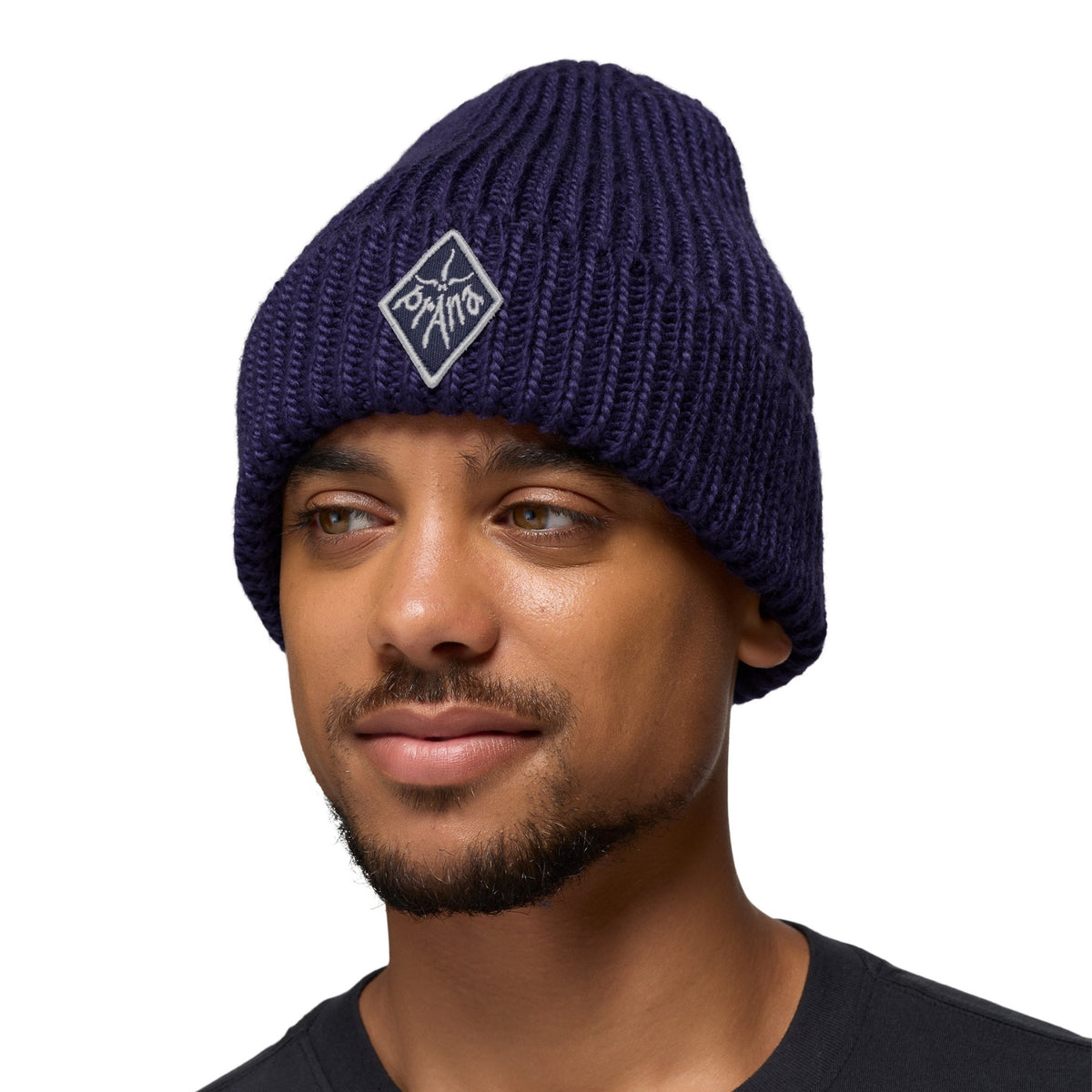 Man wearing a navy blue beanie with a logo on a white background