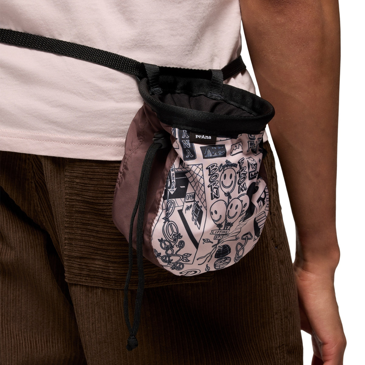 Person wearing a Prada waist bag with a unique pattern on a neutral background