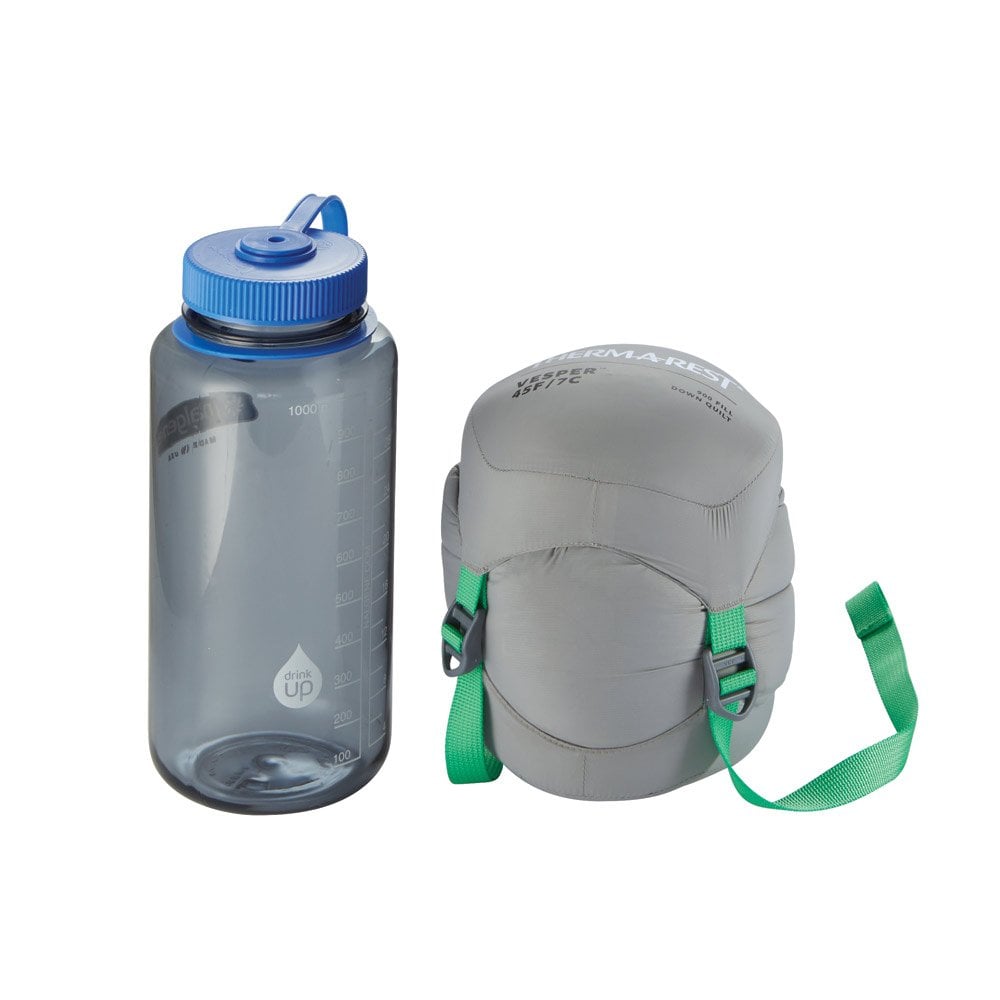 Thermarest Vesper 45F/7C Quilt in dark faded green packed up next to nalgene