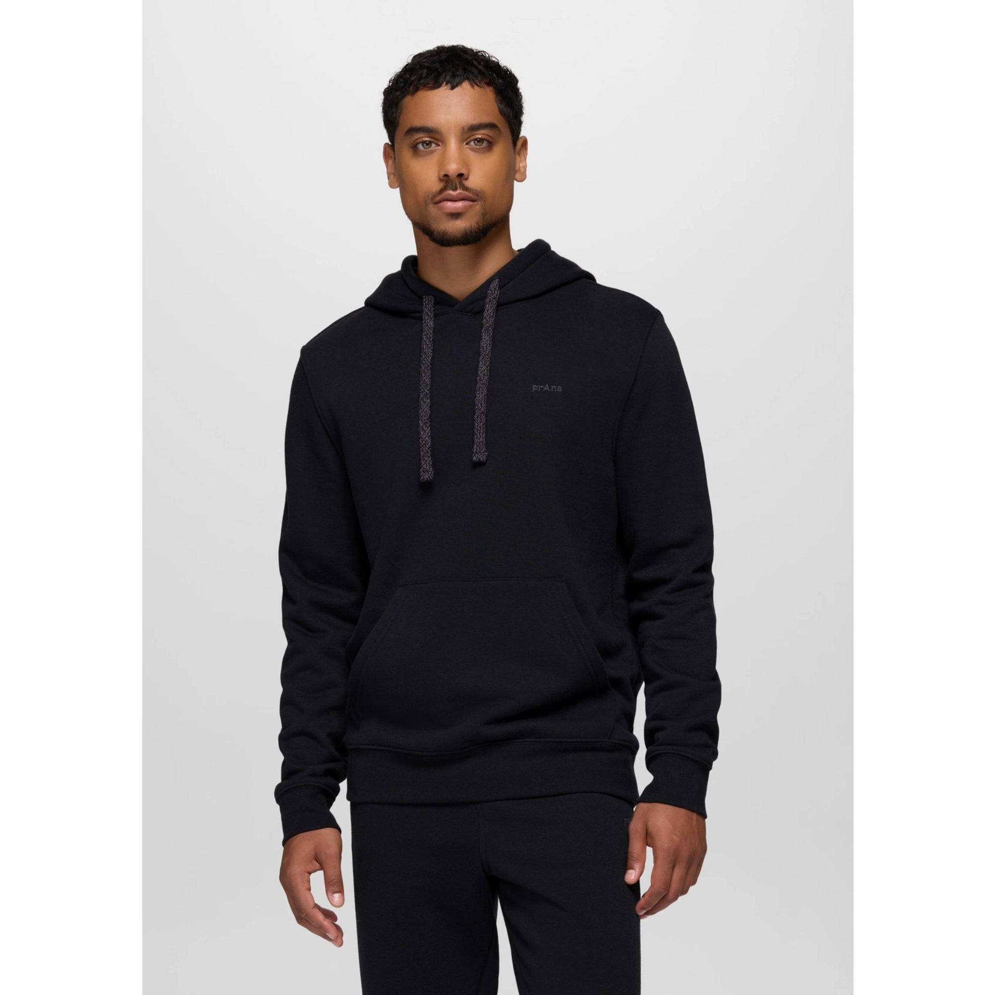 Man wearing a black hoodie on a light gray background