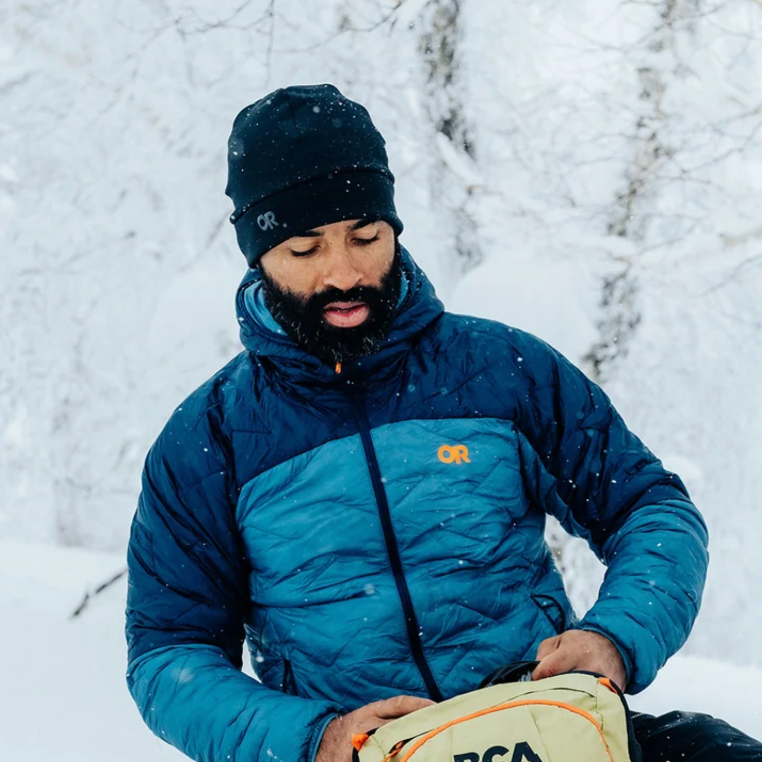 A black knit beanie hat with a folded cuff and a small white 'OR' logo on the front, shown against a plain white background.