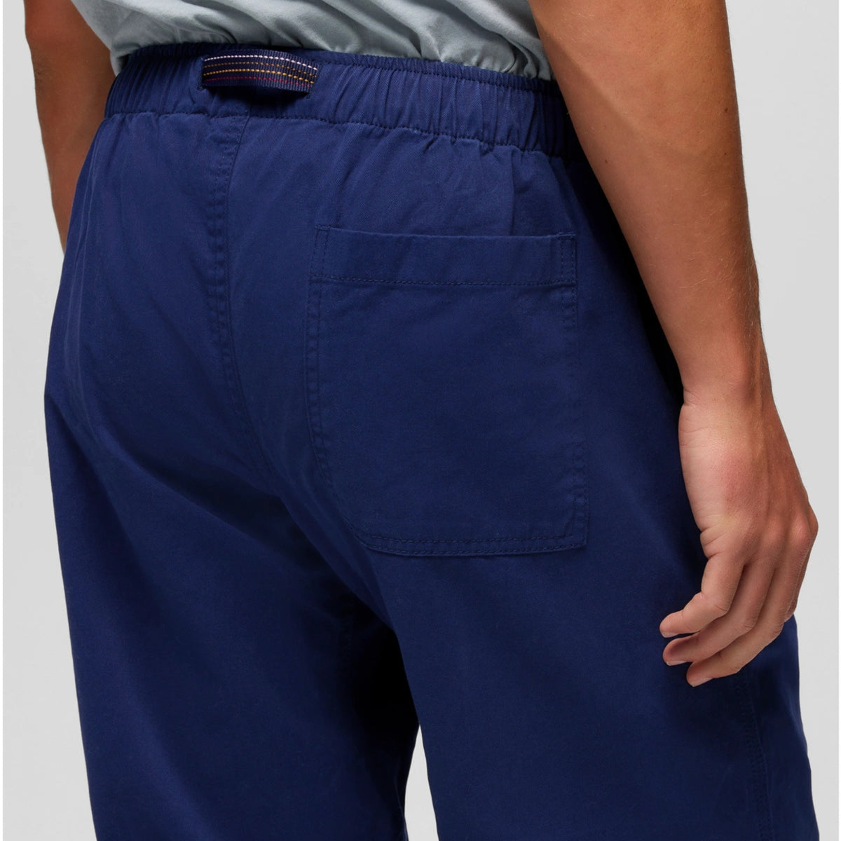 Navy blue pants worn by a person on a light gray background