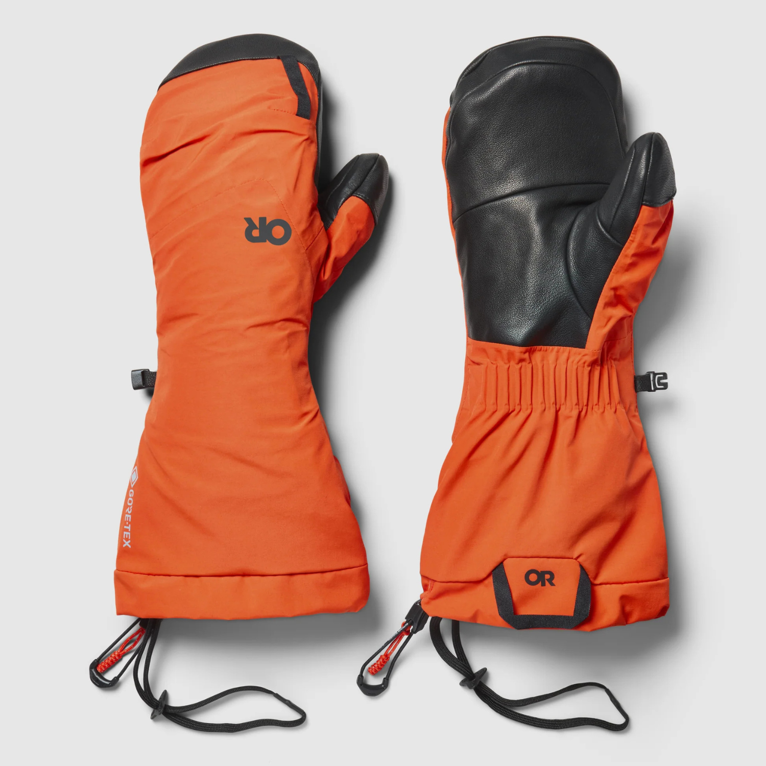 A pair of orange and black OR mountaineering mittens shown flat against a light grey background, displaying both the front and back views.