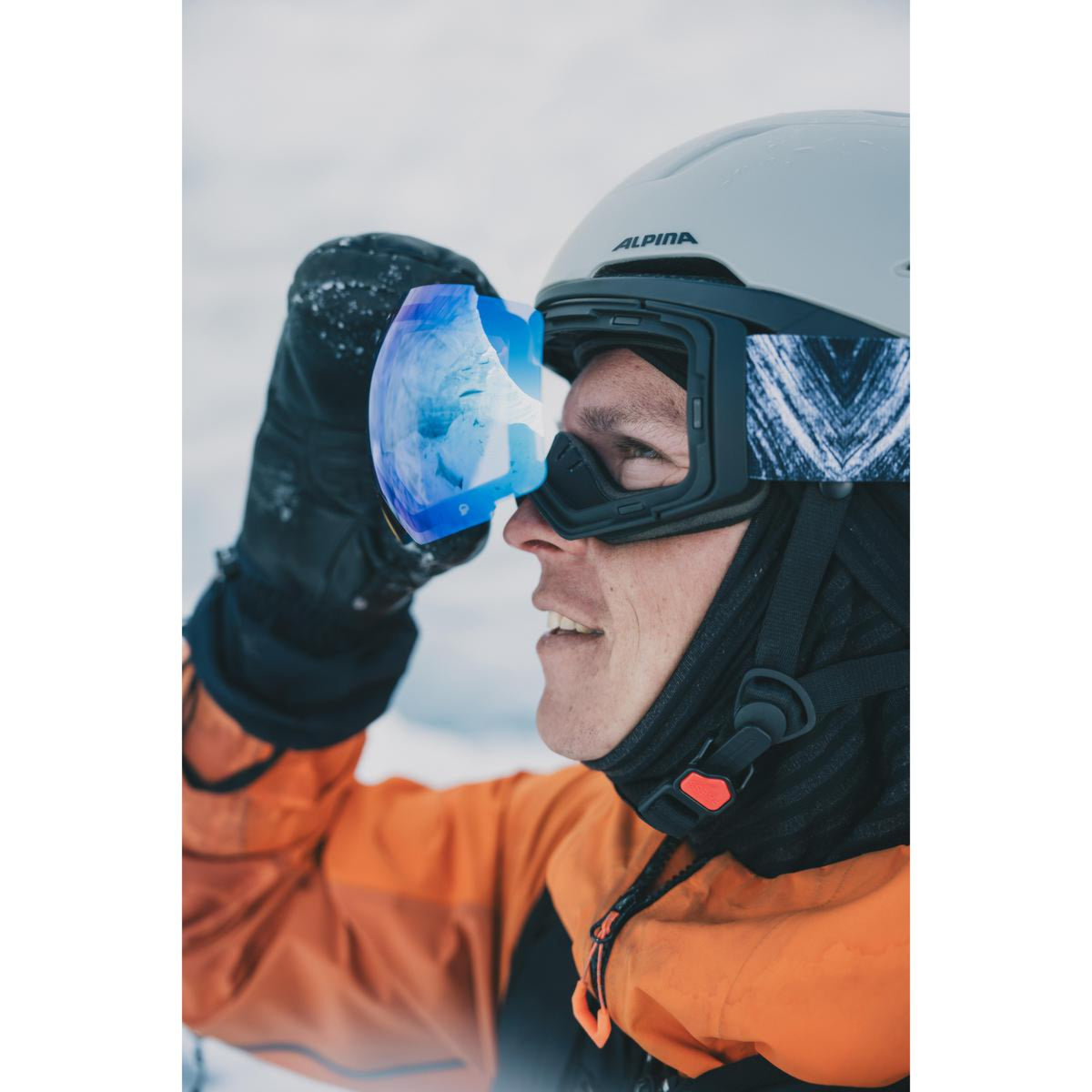 Person wearing a helmet and goggles with a snowy background
