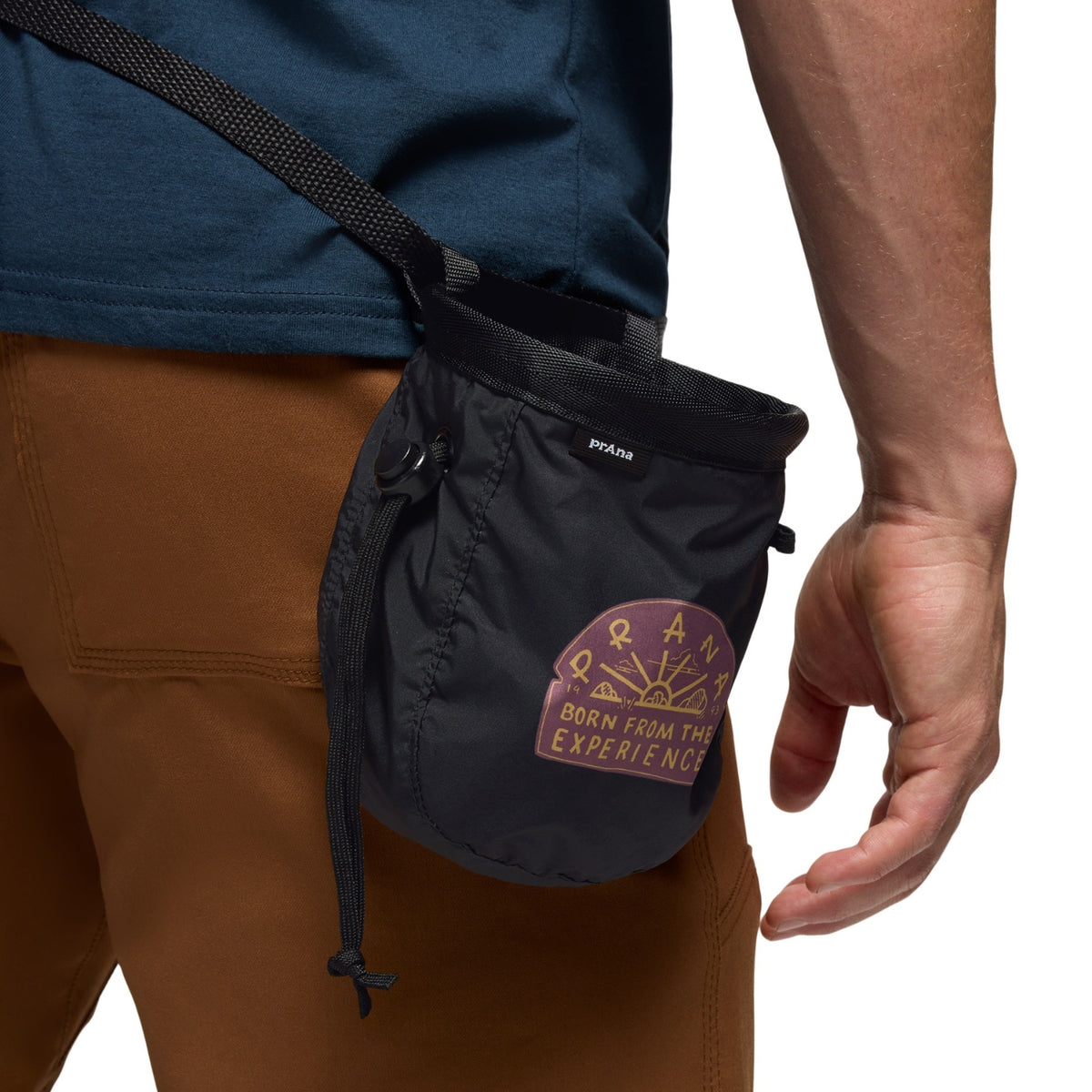 Black chalk bag with a brand logo worn on a person's waist against a white background