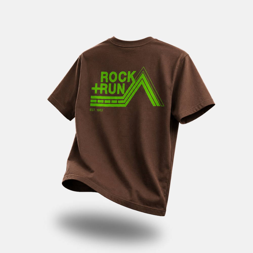 A brown short-sleeve t-shirt with a bright green 'ROCK+RUN' mountain logo printed on the back, shown against a light gray background with a soft drop shadow.