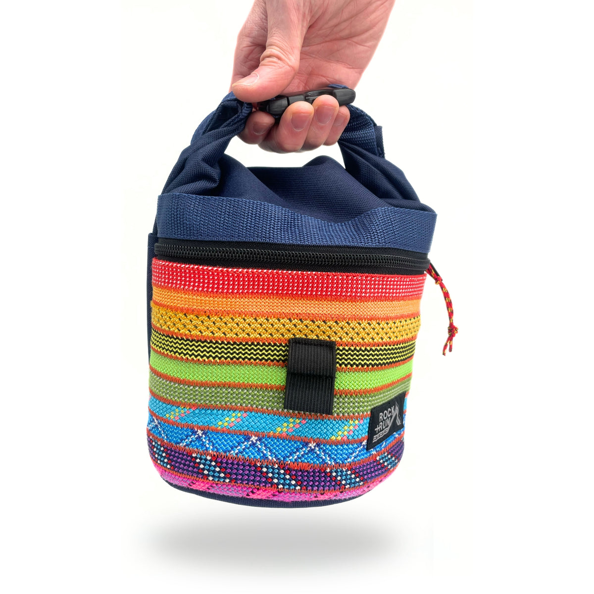 Colorful chalk bag with a pattern held by a hand on a white background