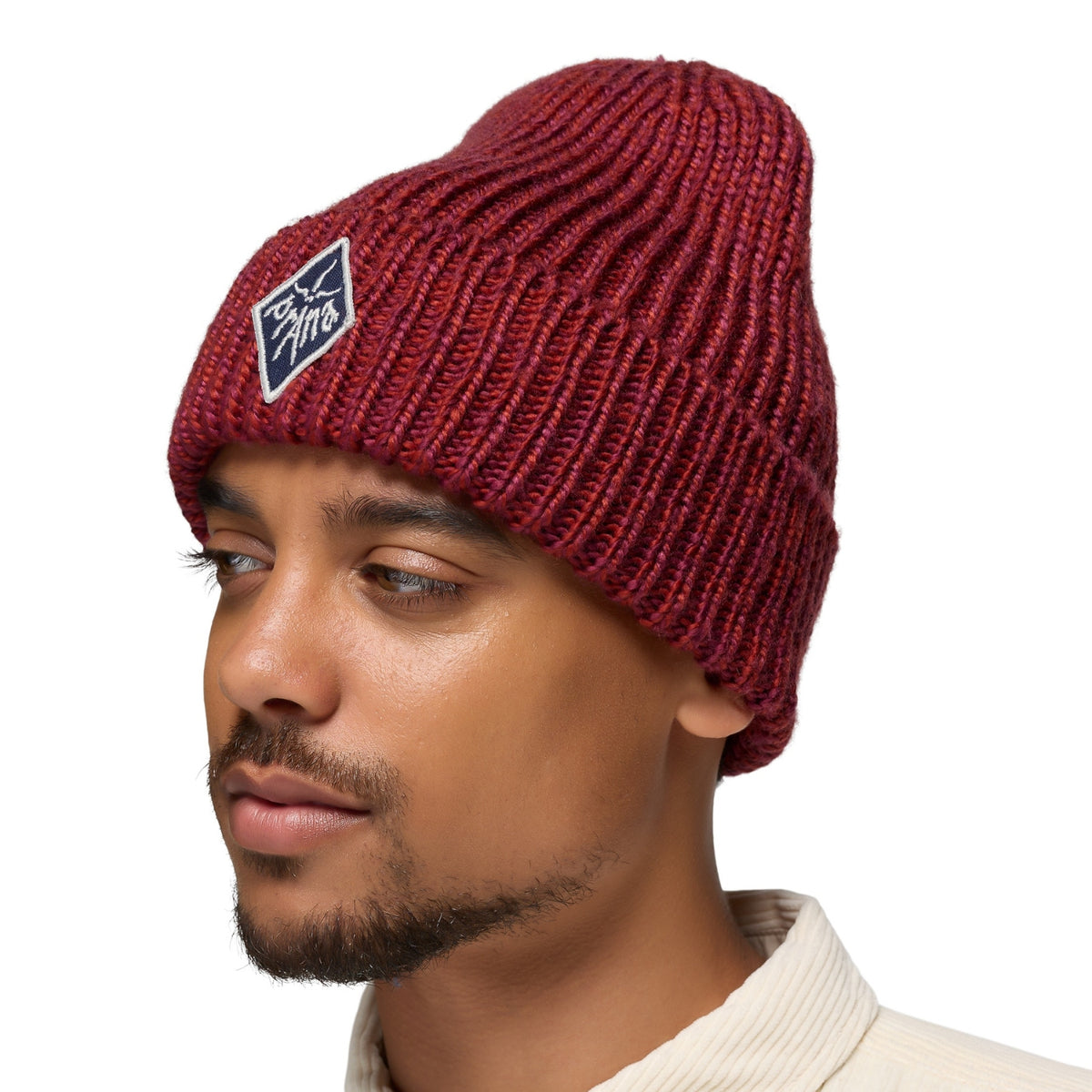 Man wearing a red knit beanie with a logo on a white background