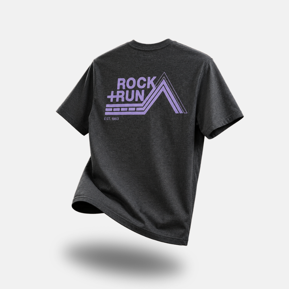 A dark heather gray t-shirt with a purple 'ROCK+RUN' graphic on the back, shown floating against a light gray background with a soft shadow underneath.