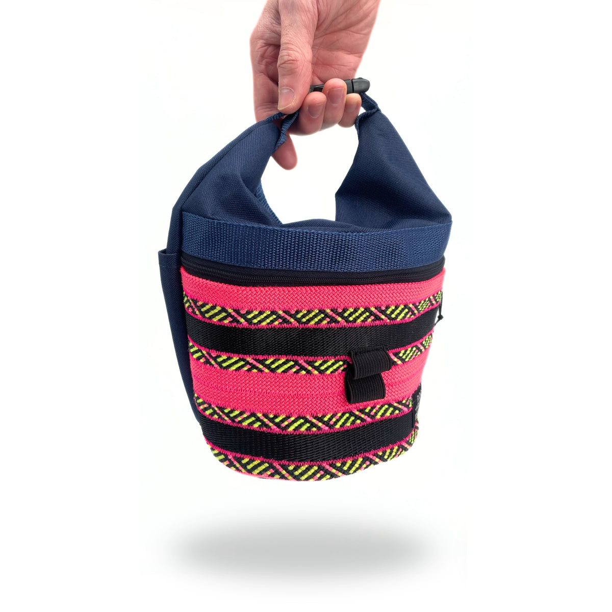 Hand holding a blue and pink chalk bag with black and yellow striped band on a white background