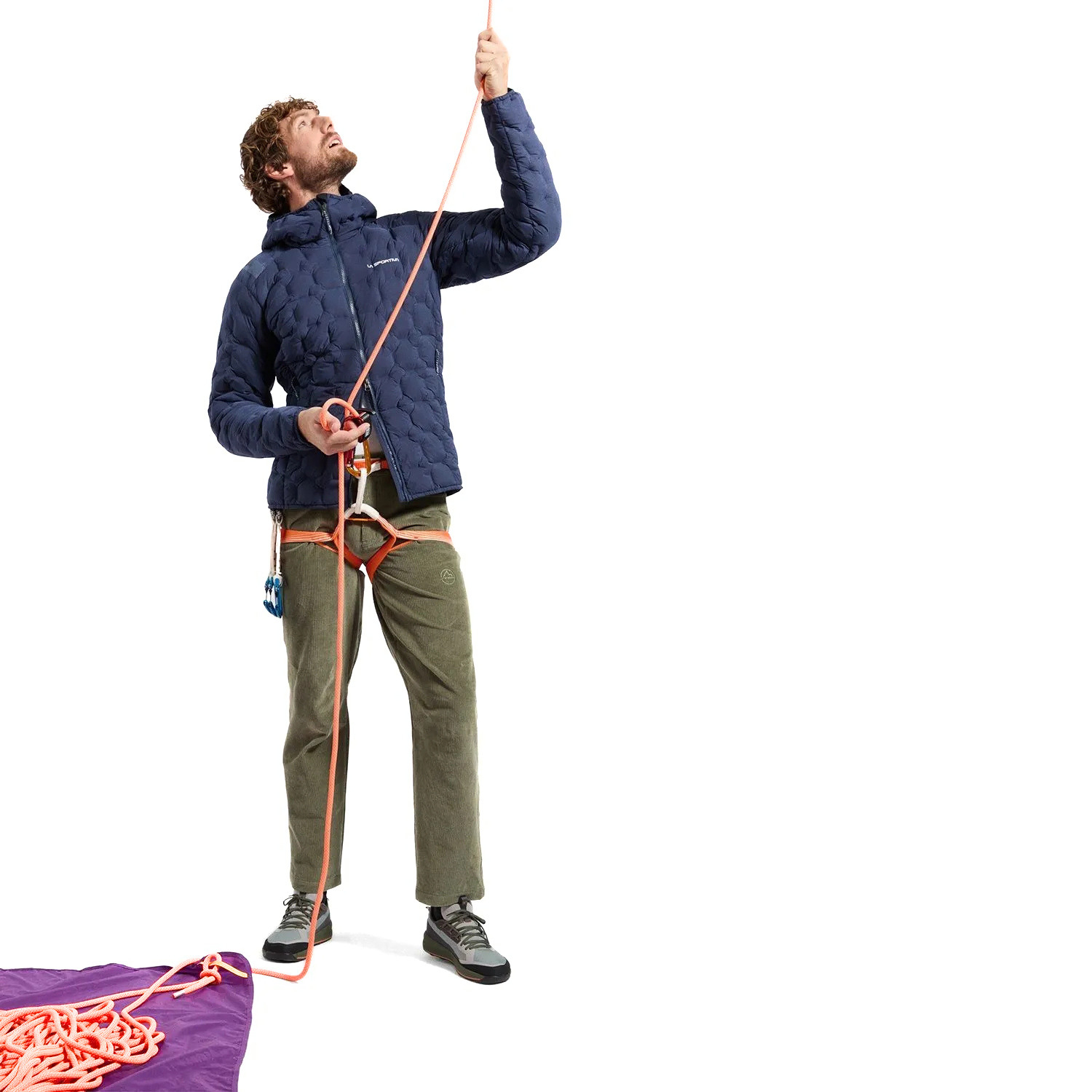 A person wearing olive green corduroy pants, a white t-shirt, and gray hiking shoes, shown from the waist down on a white studio background.