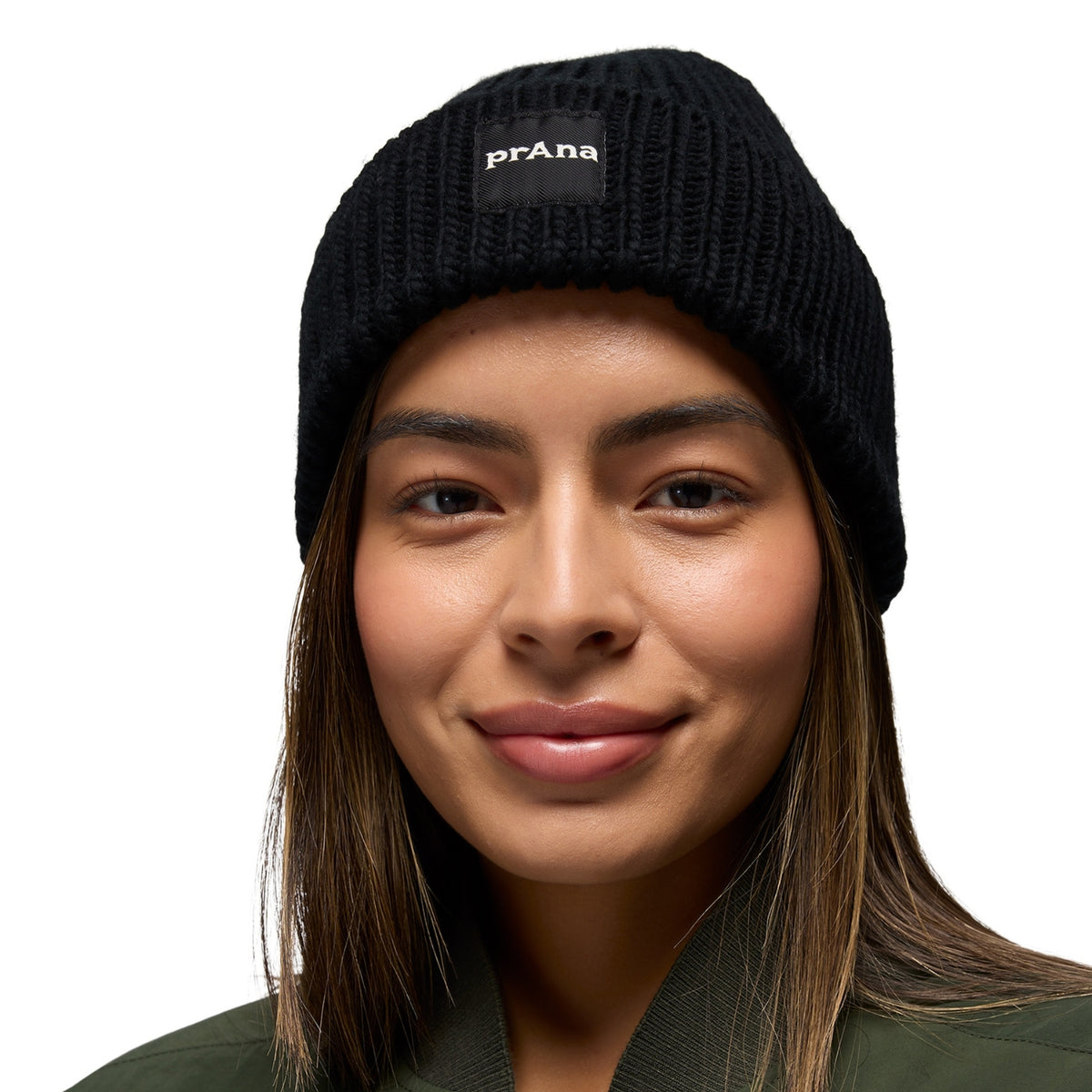 Person wearing a black knit beanie with 'prAna' logo on a white background