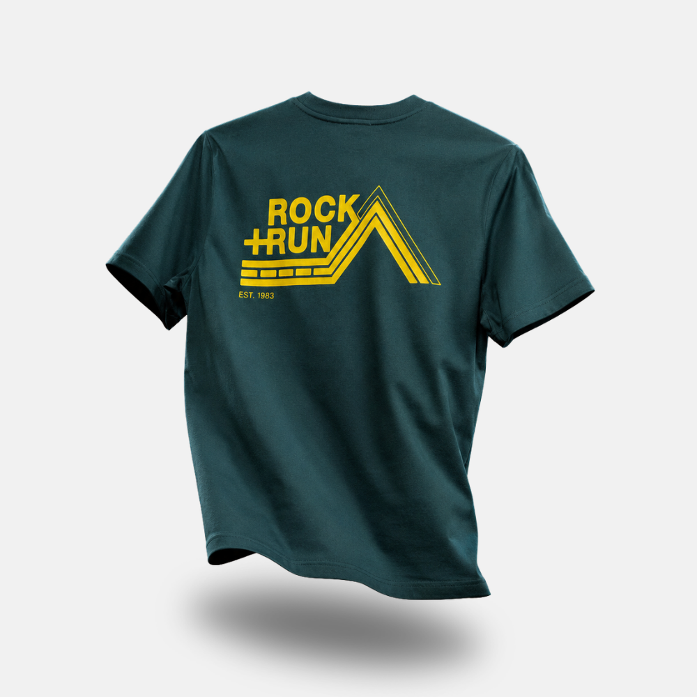A purple short-sleeve t-shirt with a yellow graphic on the back reading 'ROCK + RUN' and 'EST. 1983', shown floating against a light gray background.