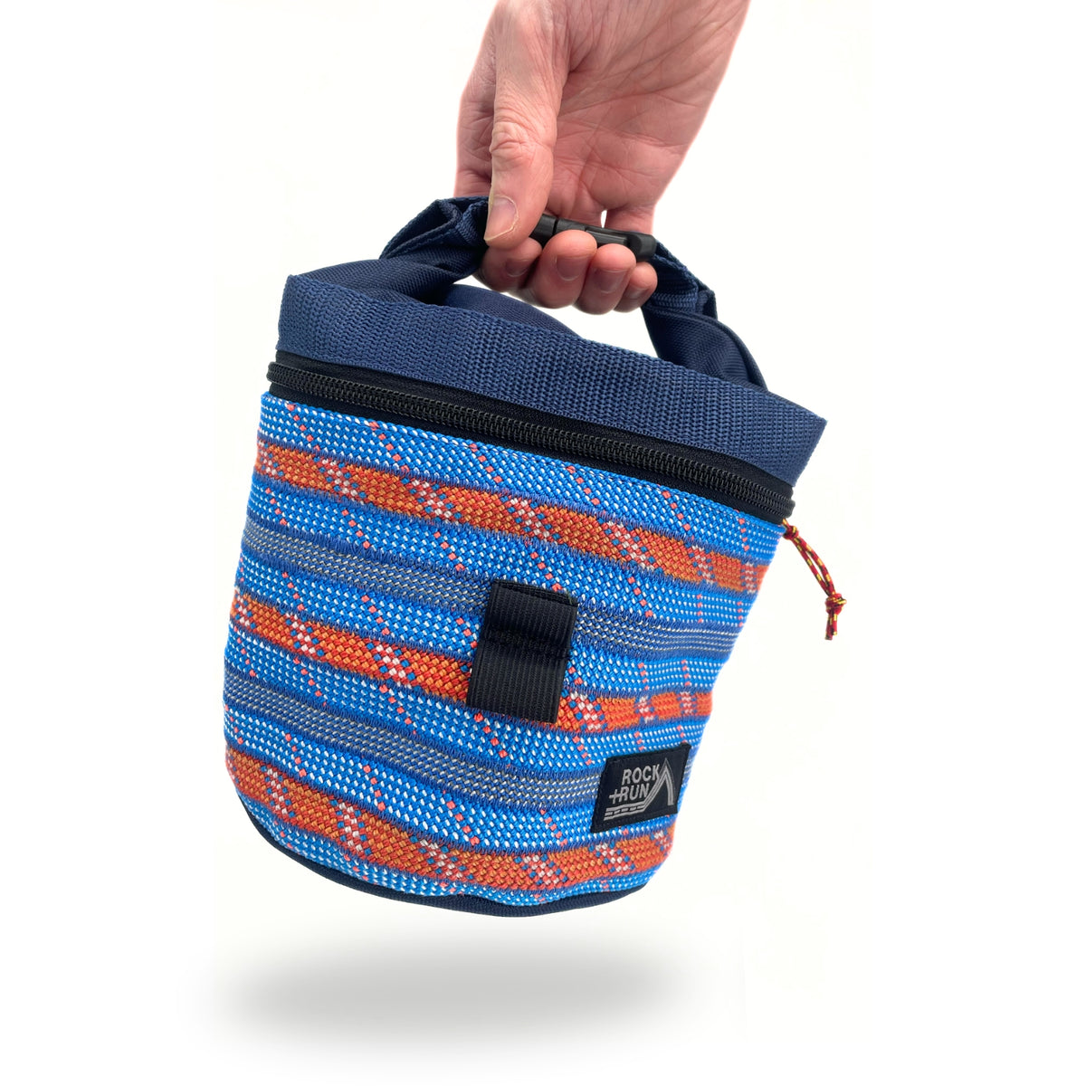 Blue and orange striped bag with a hand holding it on a white background