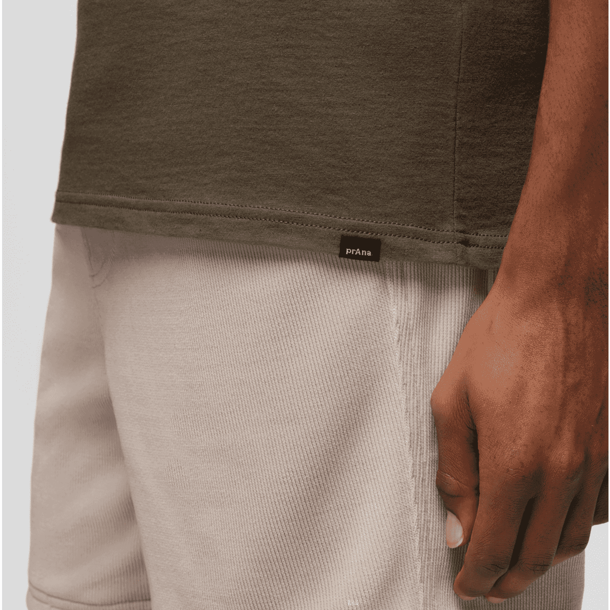 Close-up of Prana Lands Beginning T-Shirt hem with branded tag, emphasizing quality stitching and eco-friendly fabric.