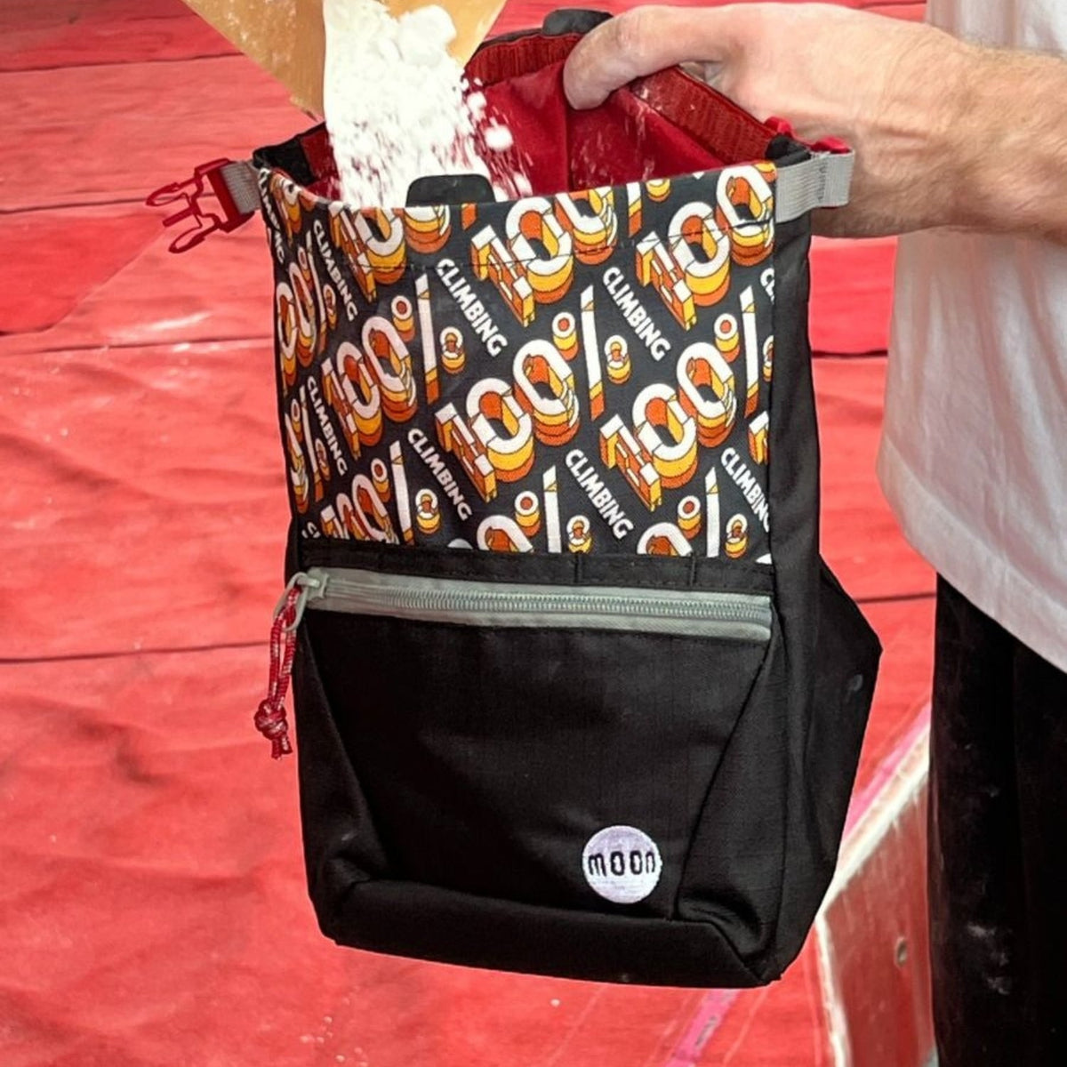 Black chalk bag with colourful patterned front section on a red background