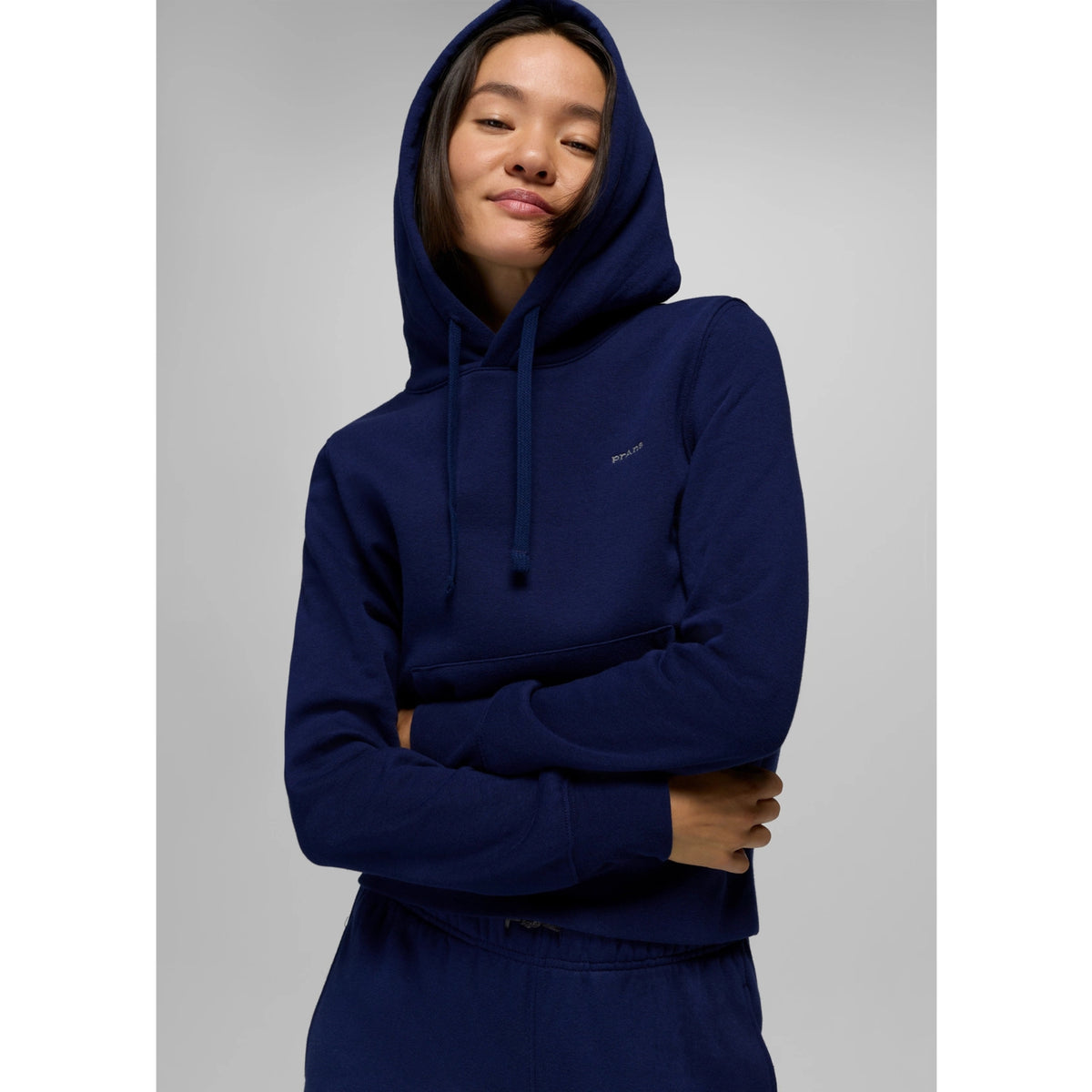 Person wearing a navy blue hoodie on a gray background
