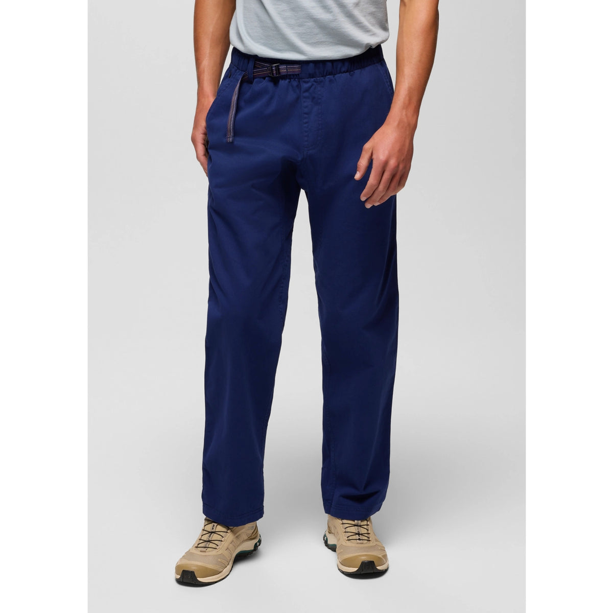 Person wearing navy blue pants on a gray background