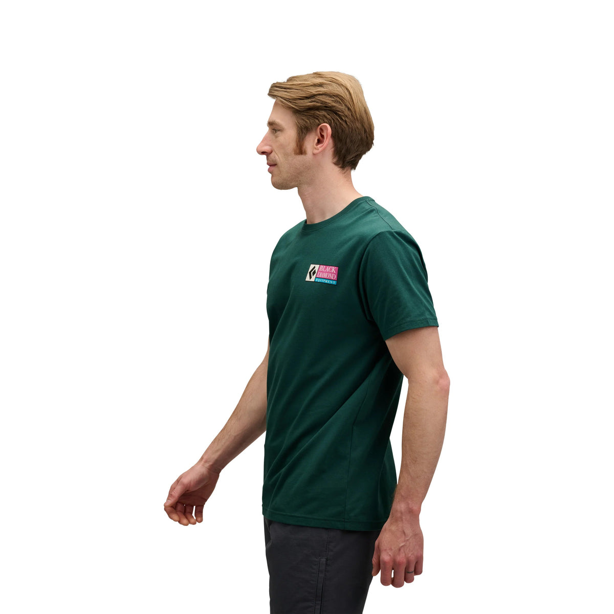 Man wearing a green t-shirt with a logo on a white background