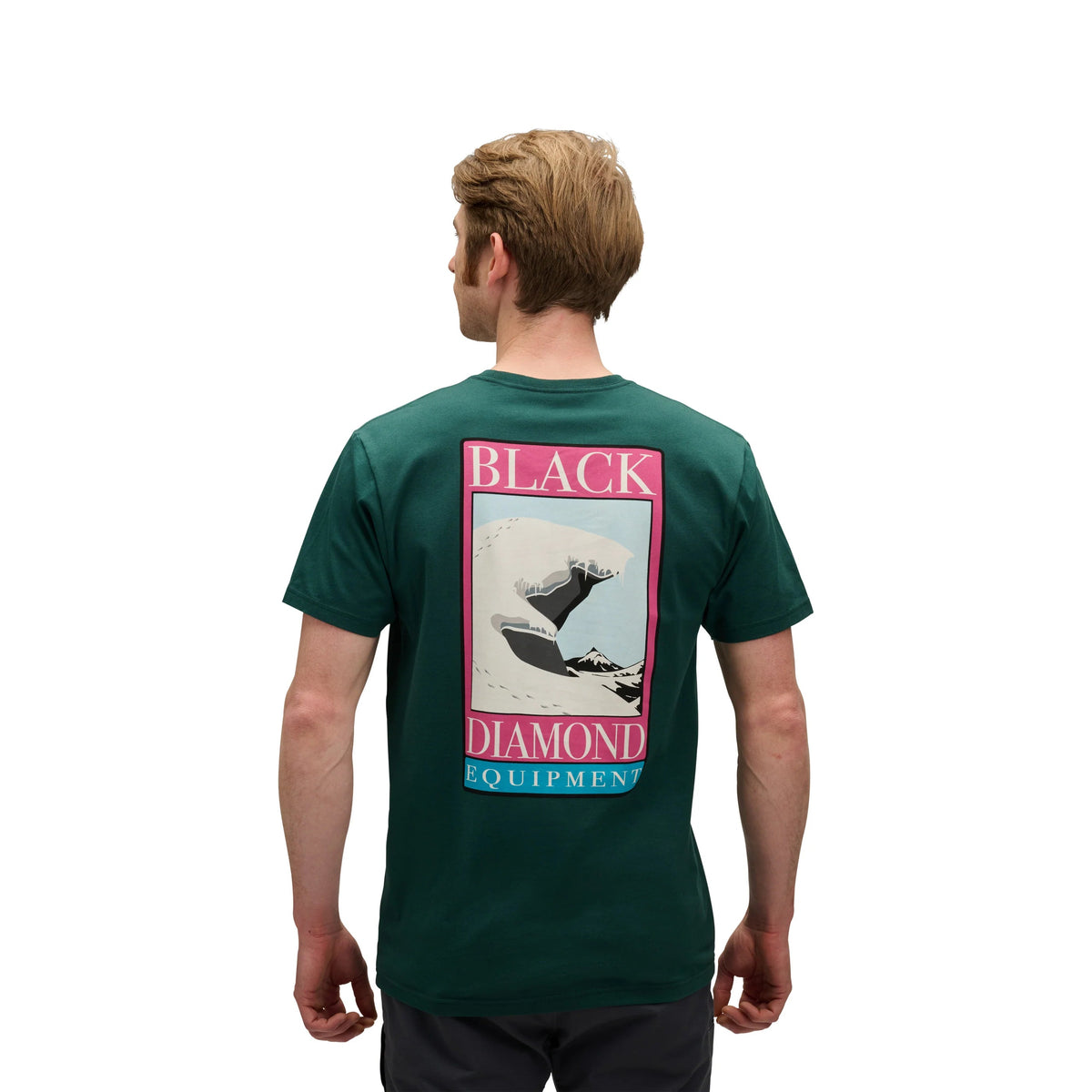 Person wearing a green t-shirt with a graphic on the back, standing against a white background
