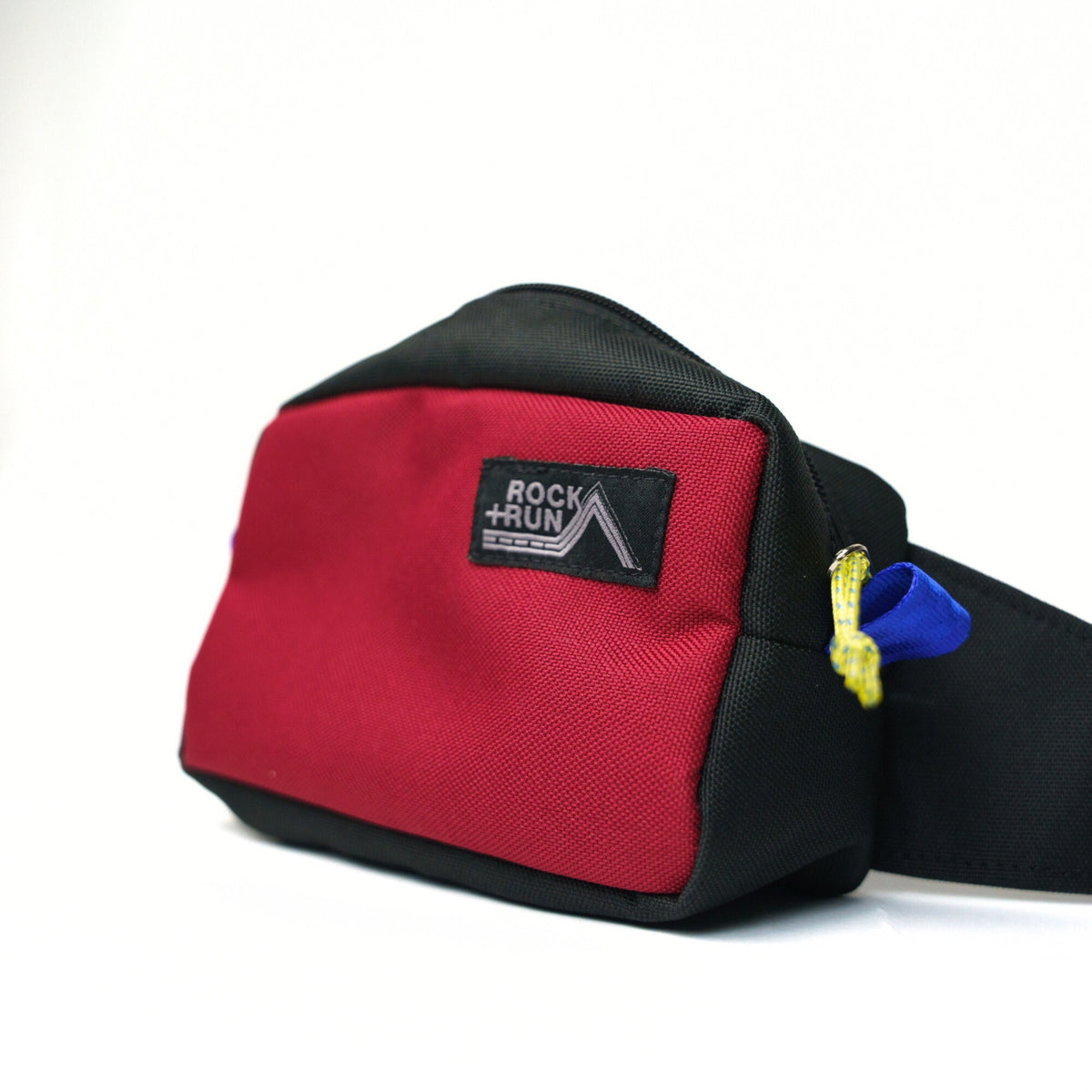 Rock+Run Drone Pack travel waist pack in red and black with zippered compartments, ideal for carrying passport, wallet, and phone on the go.