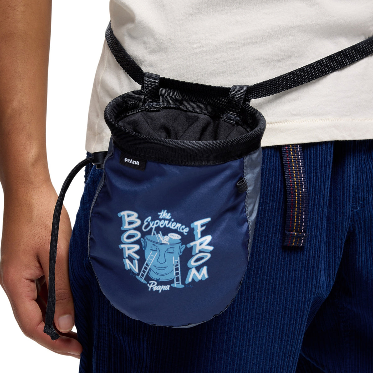 Blue chalk bag with branding held by a person wearing blue pants.