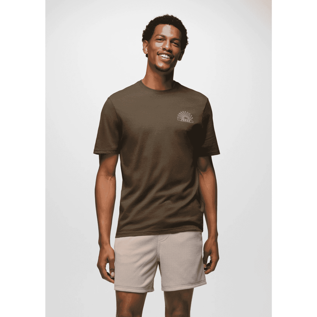 Front-facing model wearing Prana Lands Beginning T-Shirt in brown, styled with shorts for a relaxed, eco-conscious look.