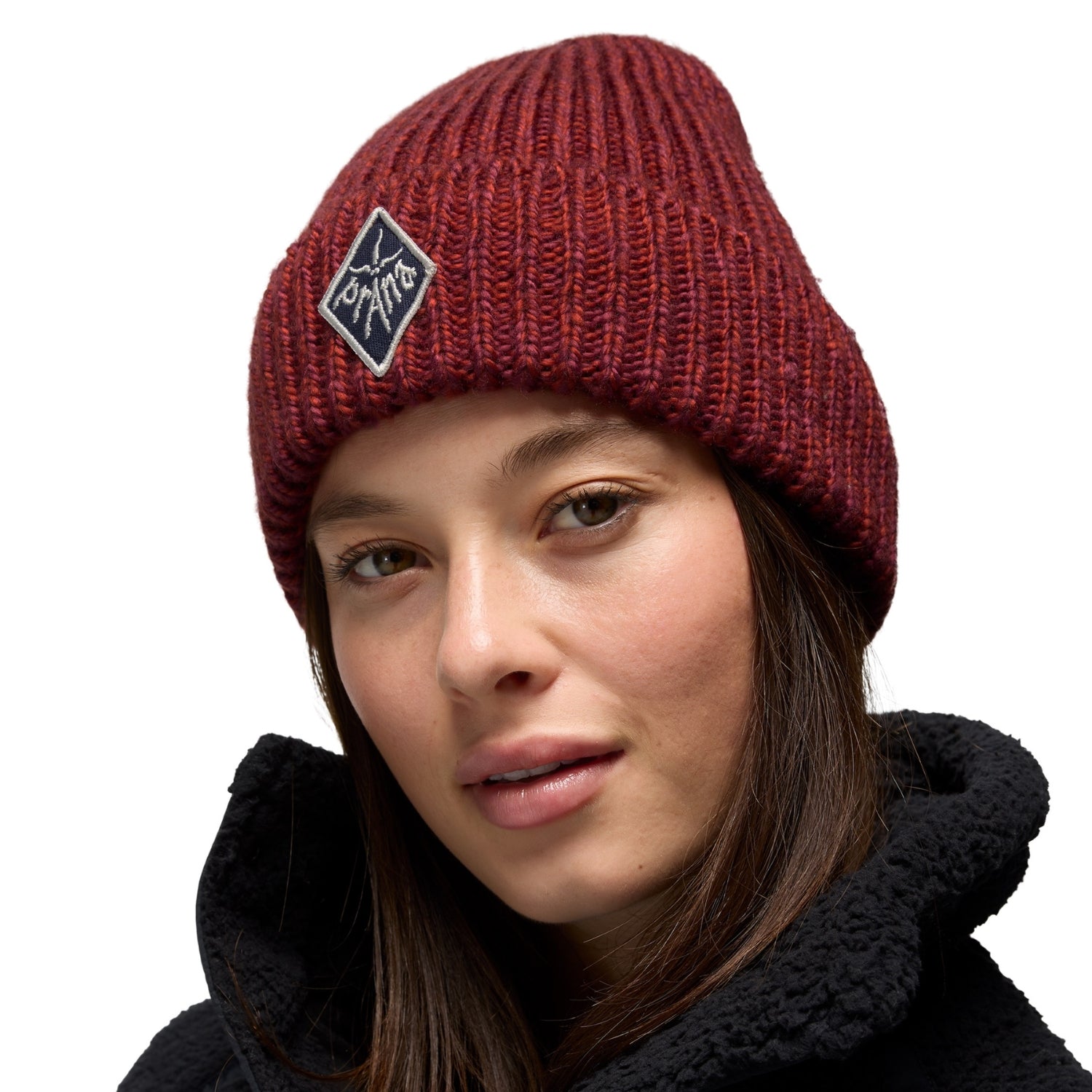 Person wearing a red beanie with a logo on a white background