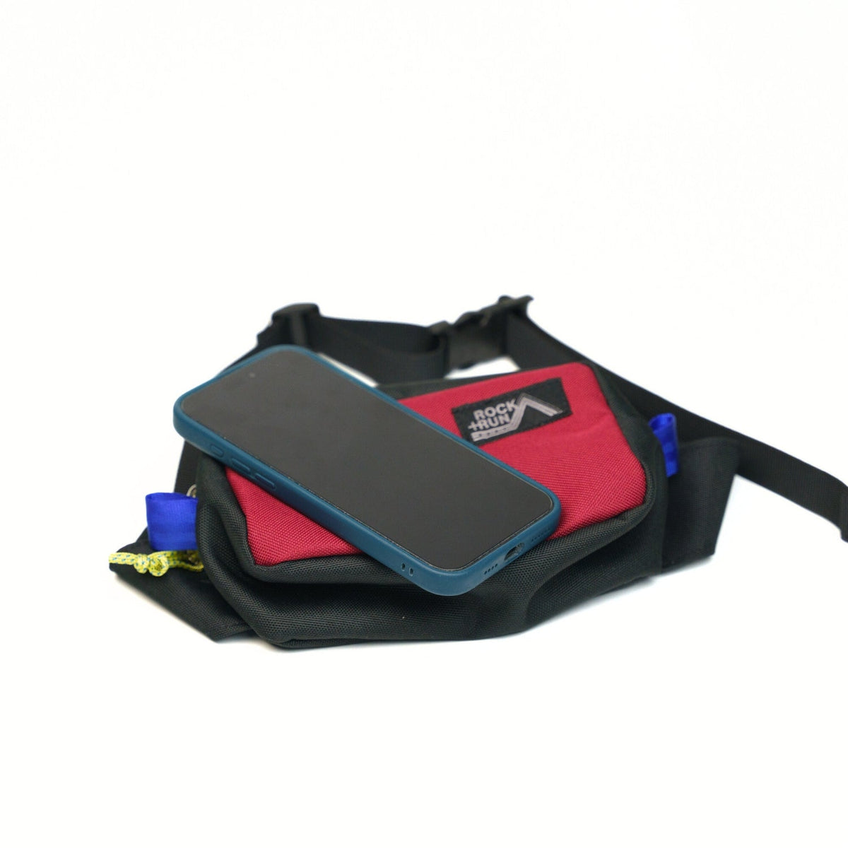 Rock+Run Drone Pack travel waist pack in red and black with phone on top, ideal for carrying passport, wallet, keys, and travel essentials