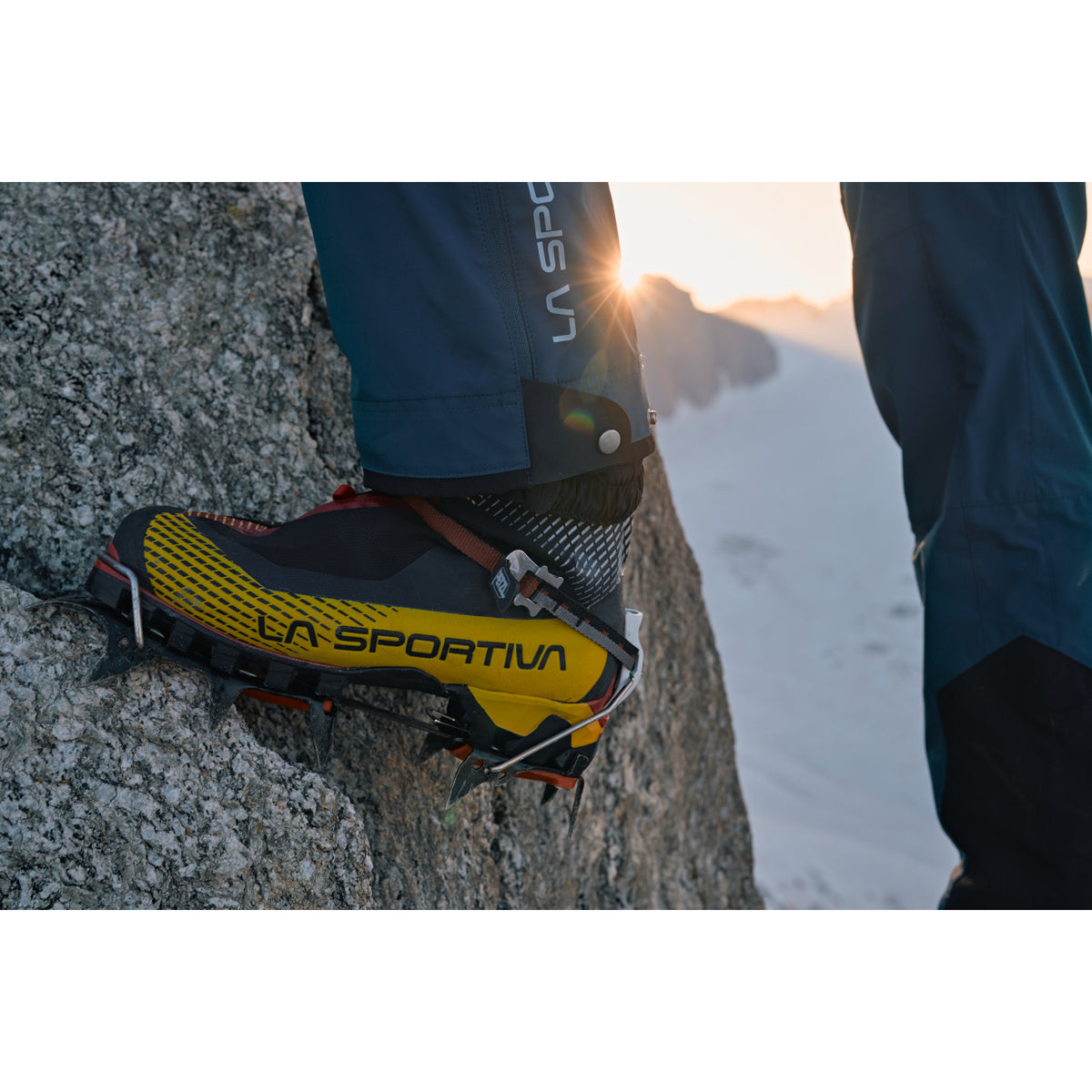 La Sportiva G-Tech mountaineering boots in black red and yellow, being used to climb in