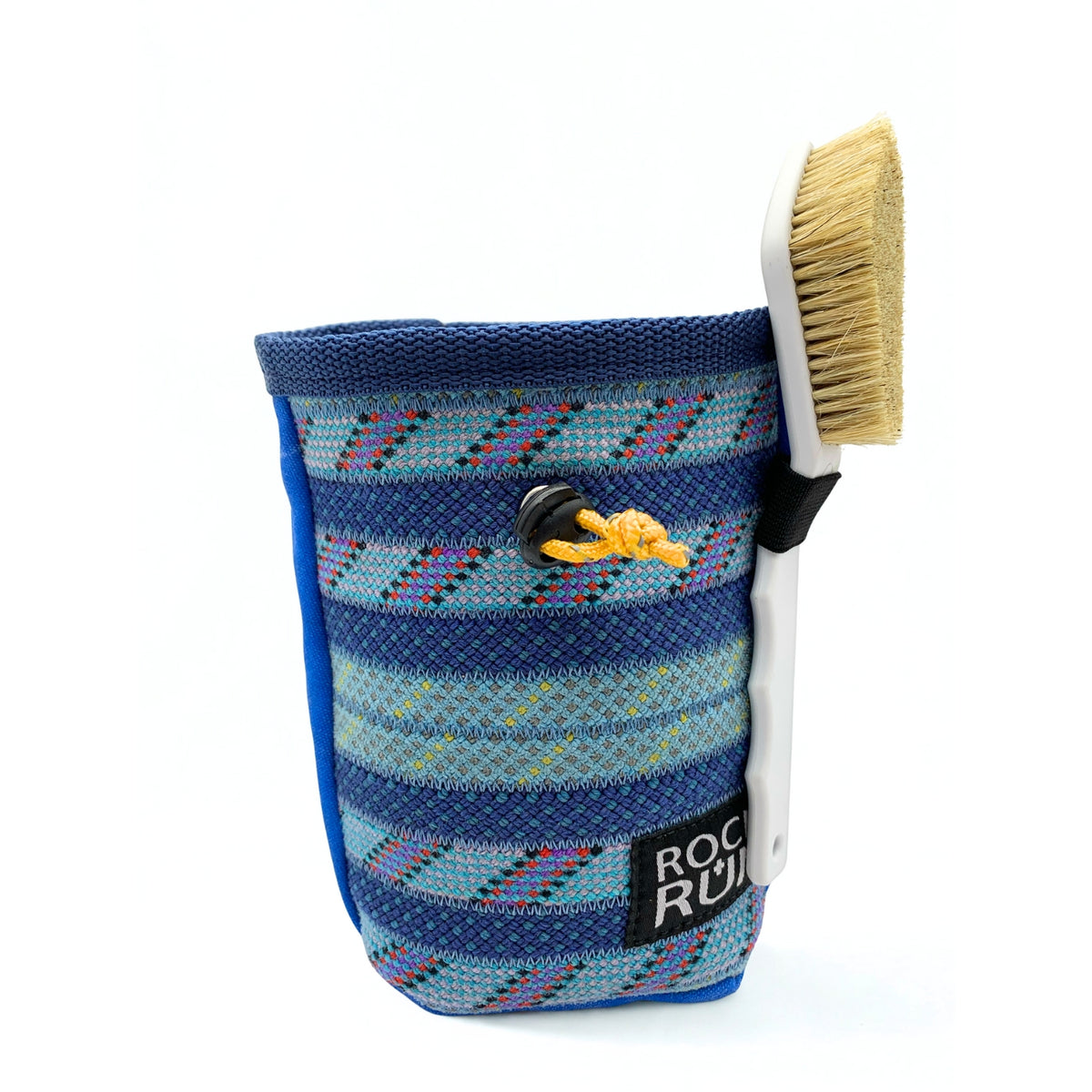 Blue patterned chalk bag with a brush attached on a white background