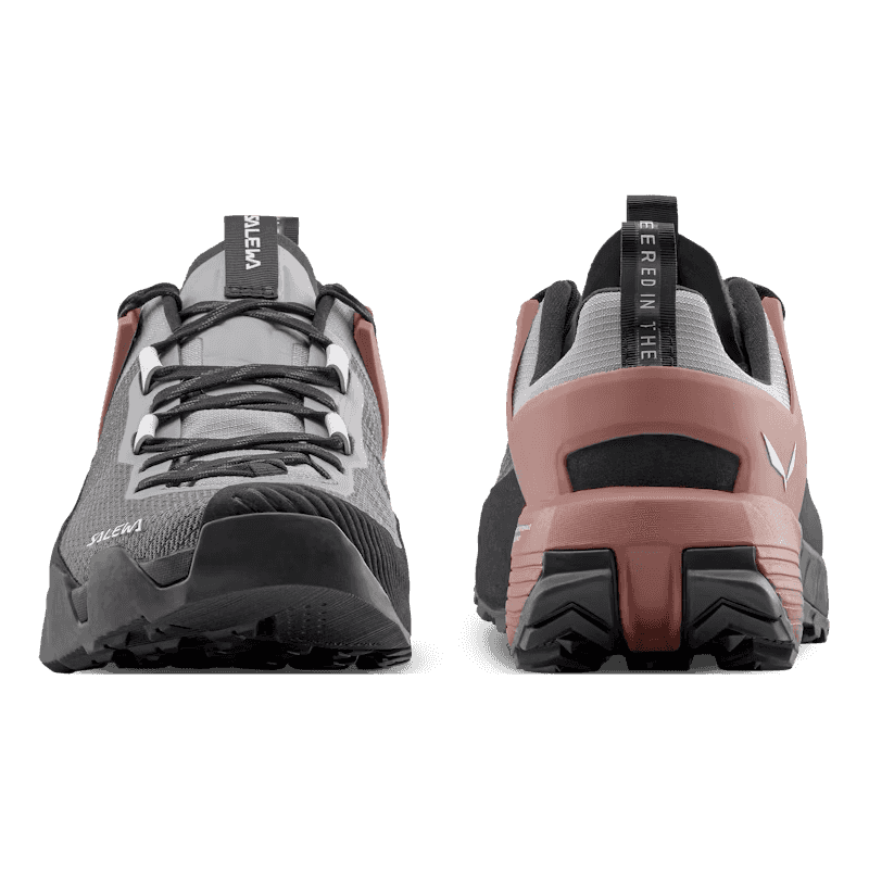 Pair of gray and pink hiking shoes with brand logo on a transparent background