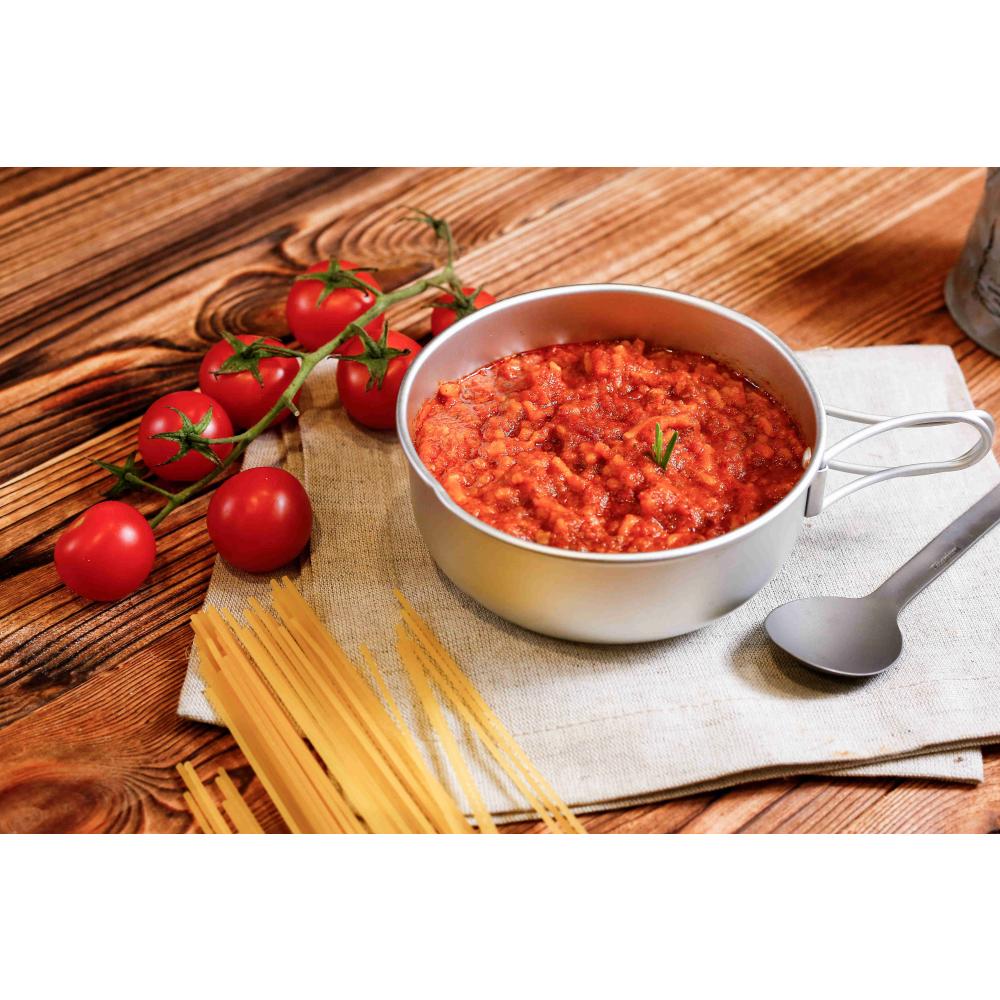 Expedition Foods Spaghetti Bolognese shown in bowl, next to a spoon and fresh ingredients
