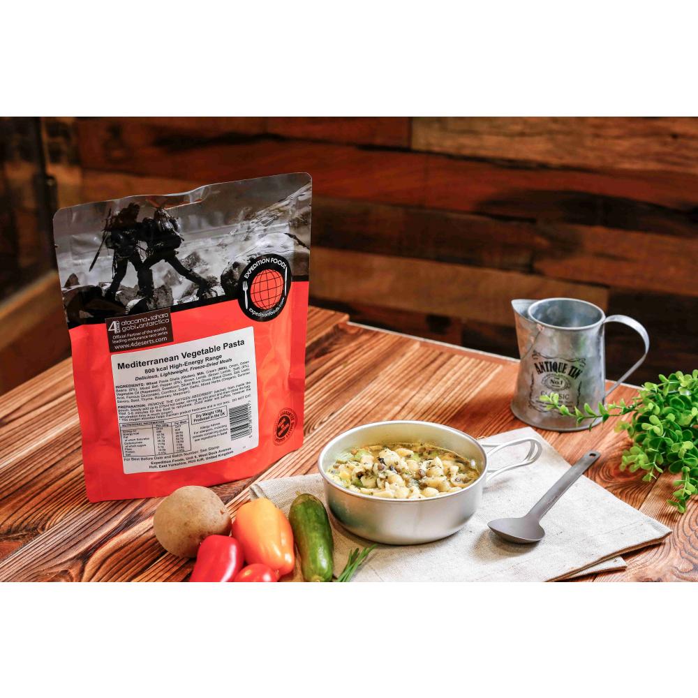 Expedition Foods Mediterranean Vegetable Pasta pack, shown on table next to food in bowl