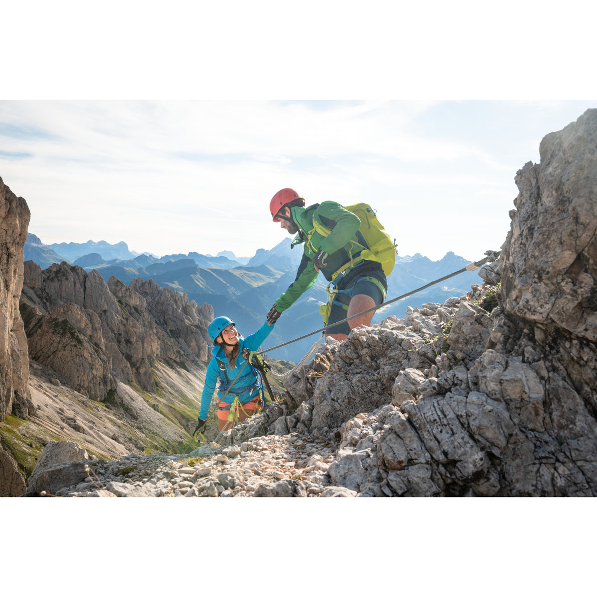 Edelrid Ultralight helmet in icemint and red colour. being used to climb via ferrata